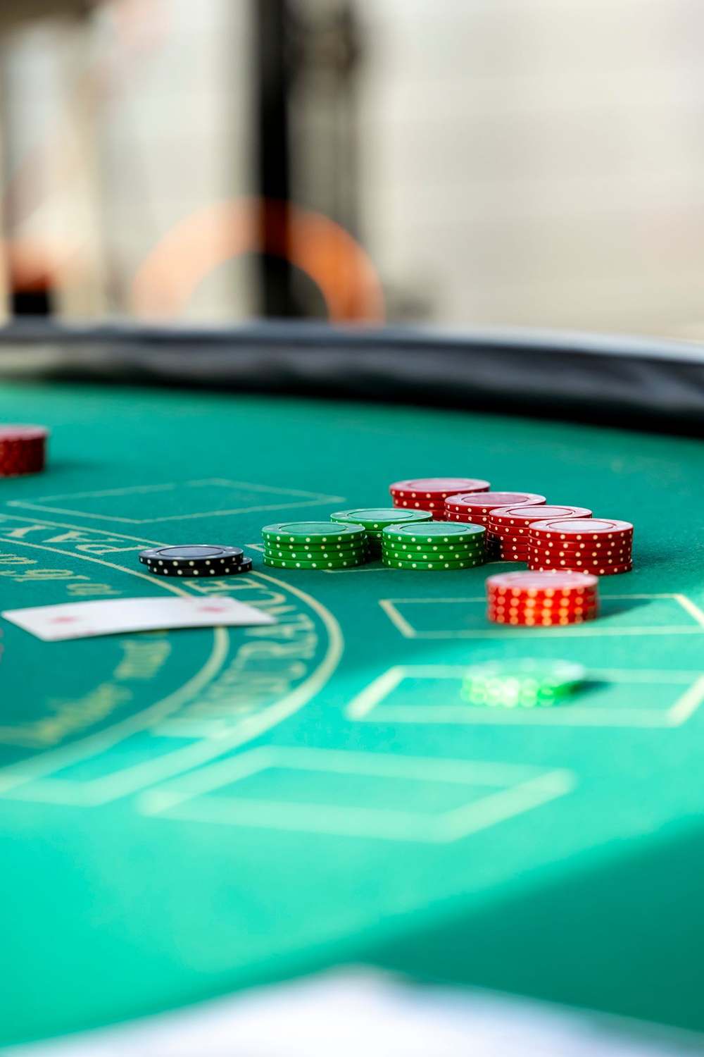 Keripik kasino dan kartu remi tersebar di meja blackjack