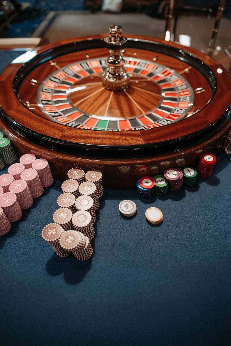 Meja roulette dengan roda dan keripik kasino dilihat dari atas