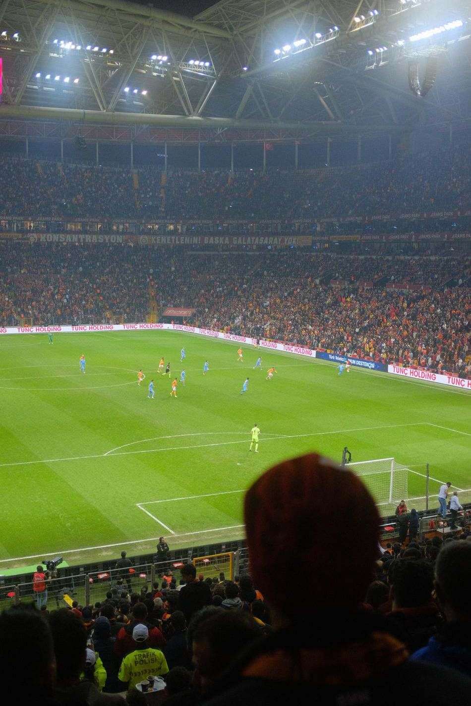 Stadion sepak bola dengan lampu menyala di malam pertandingan